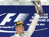 Mercedes driver Lewis Hamilton of Britain lifts up his winning trophy on the podium after the Formula One Singapore Grand Prix at the Marina Bay street circuit on September 21, 2014