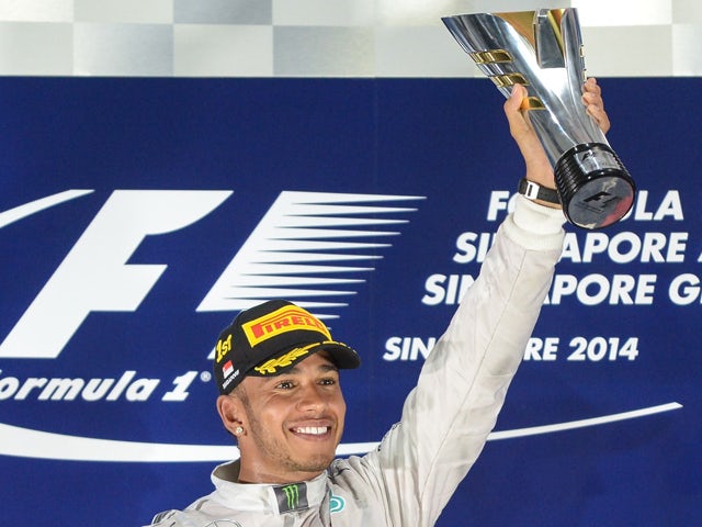 Mercedes driver Lewis Hamilton of Britain lifts up his winning trophy on the podium after the Formula One Singapore Grand Prix at the Marina Bay street circuit on September 21, 2014