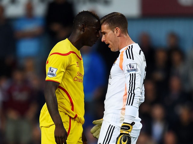 Mario Balotelli of Liverpool and Adrian of West Ham clash following a heavy tackle by Balotelli on Adrian during the Barclays Premier League match between West Ham United and Liverpool at Boleyn Ground on September 20, 2014