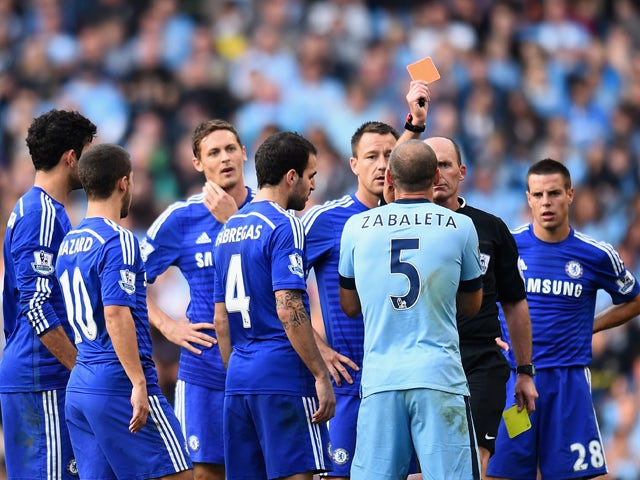 Referee Mike Dean shows a red card to Pablo Zabaleta of Manchester City during the Barclays Premier League match between Manchester City and Chelsea at the Etihad Stadium on September 21, 2014