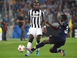 Paul Pogba (L) of Juventus is tackled by Pa Konate of Malmo FF during the UEFA Champions League Group A match between Juventus and Malmo FF on September 16, 2014