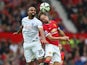 Raniere Sandro of QPR goes up for a header with Daley Blind of Manchester United during the Barclays Premier League match between Manchester United and Queens Park Rangers at Old Trafford on September 14, 2014 