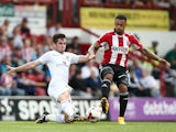 Andre Gray of Brentford tackles Lewis Cook of Leeds during the Sky Bet Championship match between Brentford and Leeds United at Griffin Park on September 27, 2014