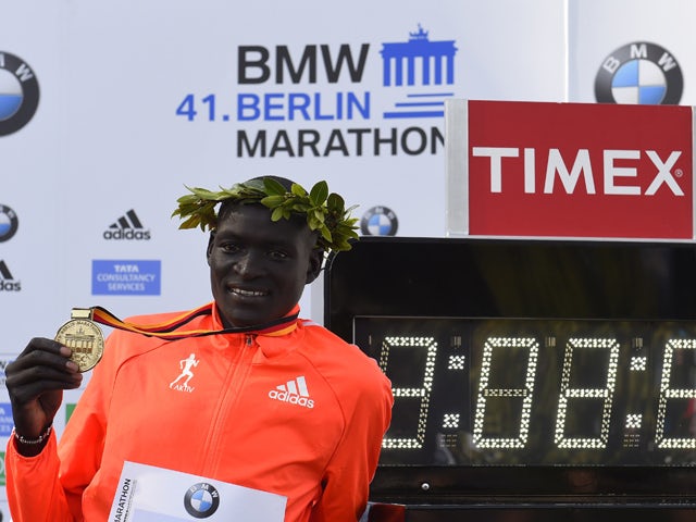 Kenya's Dennis Kimetto poses with his gold medal next to a display showing the time in which he won the 41th edition of the Berlin Marathon in Berlin on September 28, 2014