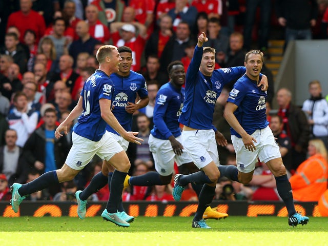 Phil Jagielka of Everton celebrates with teammates after scoring a late goal to level the scores at 1-1 during the Barclays Premier League match between Liverpool and Everton at Anfield on September 27, 2014
