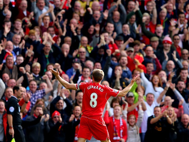 Steven Gerrard #8 of Liverpool infront of the home fans after scoring the opening goal from a free kick during the Barclays Premier League match between Liverpool and Everton at Anfield on September 27, 2014