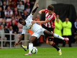 Nathan Dyer of Swansea City is tackled by Billy Jones of Sunderland during the Barclays Premier League match between Sunderland and Swansea City at Stadium of Light on September 27, 2014