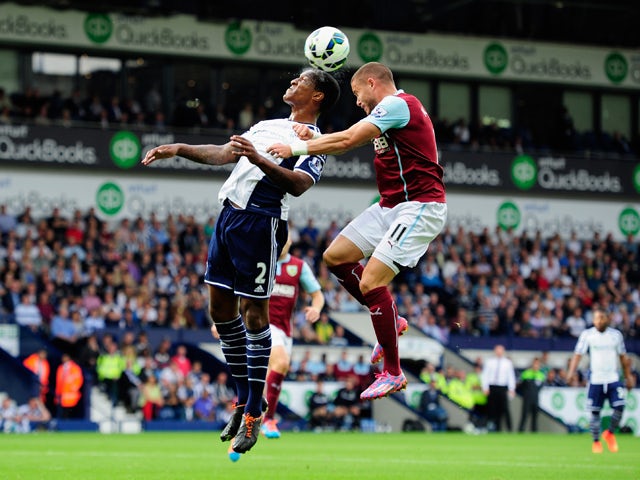 WBA player Andre Wisdom is challenged by Michael Kightly of Burnley during the Barclays Premier League match between West Bromwich Albion and Burnley at The Hawthorns on September 28, 2014
