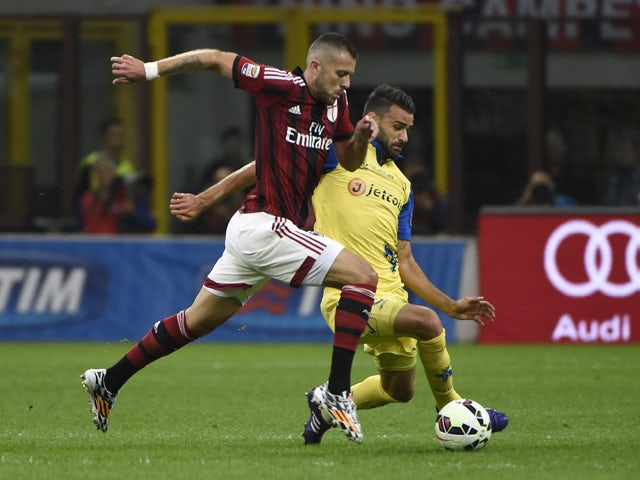 AC Milan's midfielder from France Jeremy Menez fights for the ball with Chievo's defender from Bosnia-Herzegovina Ervin Zukanovic during the Italian Serie A football match AC Milan vs Chievo Verona on October 4, 2014
