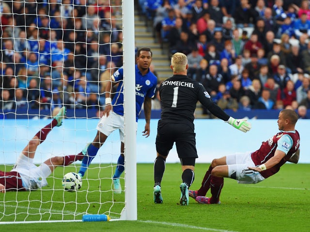 Michael Kightly of Burnley shoots past Kasper Schmeichel of Leicester City to scores their first goal during the Barclays Premier League match between Leicester City and Burnley at The King Power Stadium on October 4, 2014