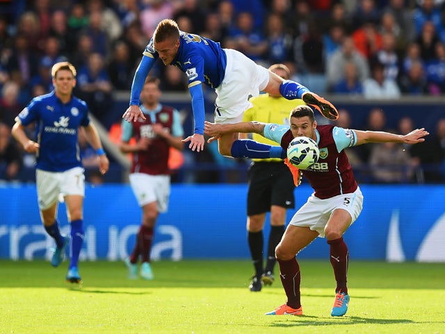 Jamie Vardy of Leicester City climbs over Jason Shackell of Burnley during the Barclays Premier League match between Leicester City and Burnley at The King Power Stadium on October 4, 2014