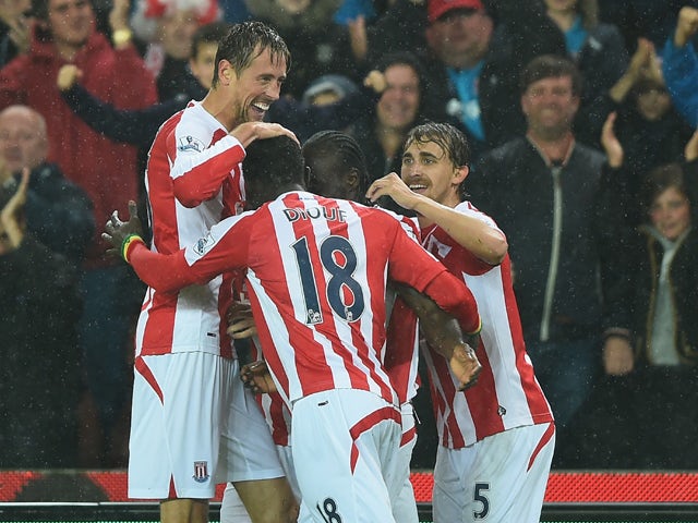 Peter Crouch of Stoke City celebrates with team-mates after scoring the opening goal during the Barclays Premier League match between Stoke City and Newcastle United at Britannia Stadium on September 29, 2014