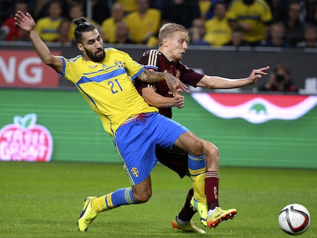 Sweden's midfielder Jimmy Durmaz (L) and Russia's defender Igor Smolnikov vie for the ball on October 9, 2014