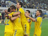 Ukraine's midfielder Serhiy Sydorchuk is embraced by forward Andrei Yarmolenko and other teammates after he scored during the UEFA 2016 European Championship qualifying round Group C match Ukraine vs Macedonia in Lviv on October 12, 2014