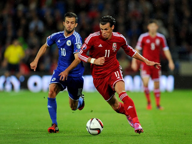 Wales striker Gareth Bale races past Bosnia player Miralem Pjanic during the EURO 2016 Qualifier match between Wales and Bosnia and Herzegovina at Cardiff City Stadium on October 10, 2014 