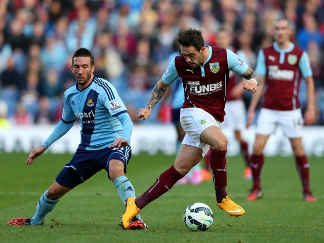 Danny Ings of Burnley is challenged by Morgan Amalfitano of West Ham during the Barclays Premier League match between Burnley and West Ham United at Turf Moor on October 18, 2014