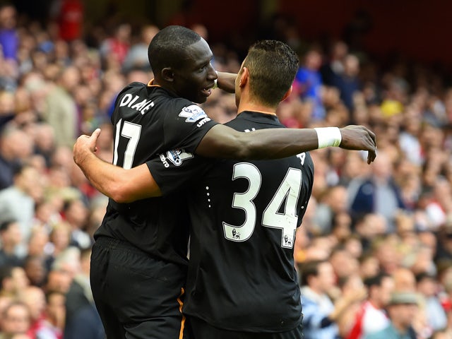 Mohamed Diame of Hull City celebrates with team-mate Hatem Ben Arfa after scoring their first goal during the Barclays Premier League match between Arsenal and Hull City at Emirates Stadium on October 18, 2014