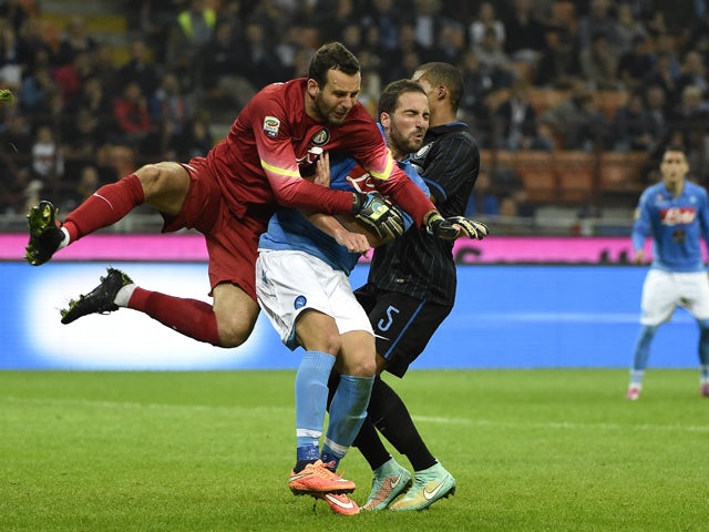 Inter Milan's goalkeeper from Slovenia Samir Handanovic jumps for the ball next to Napoli's forward from Argentina Gonzalo Higuain during the Italian Serie A football match Inter Milan vs Naples on October 19, 2014