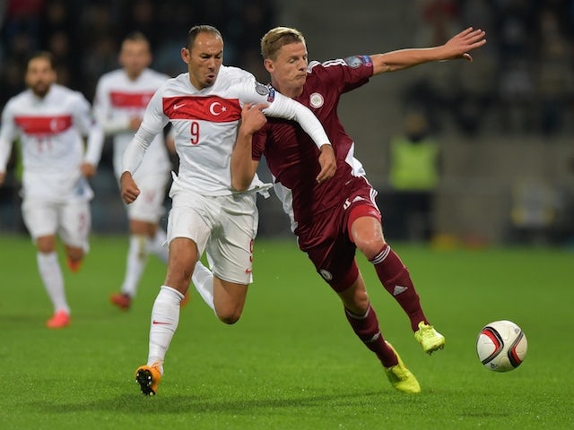 Latvia's Kaspars Dubra (R) vies with Turkey's Umut Bulut (L) during the Euro 2016 Group A qualifying football match Latvia vs Turkey in Riga, Latvia on October 13, 2014
