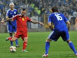 Belgium's Steven Defour (C) strikes the ball, flanked by Bosnia and Herzegovina's Vedad Ibisevic (L) and Senad Lulic (R) during the Euro 2016 qualifying match on October 13, 2014