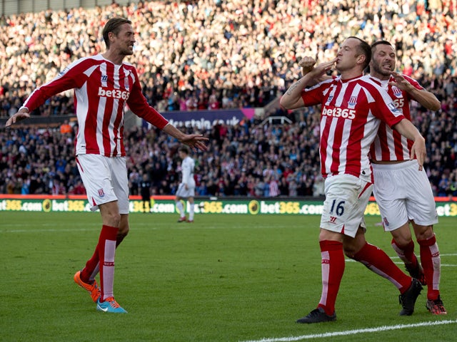 Stoke City's Scottish midfielder Charlie Adam celebrates scoring a penalty with teammate English-born Scottish defender Phil Bardsley (R) and English striker Peter Crouch (L) during the English Premier League football match between Stoke City and Swansea 