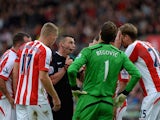 Stoke City players surround Referee Michael Oliver after he awarded Swansea City a penalty during the Barclays Premier League match between Stoke City and Swansea City at Britannia Stadium on October 19, 2014
