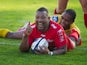 Toulon's flanker Steffon Armitage celebrates after scoring a try despite a tackle by Llanelli Scarlets' wing Michael Tagicakibau during the European Rugby Champions Cup match between Toulon and Llanelli Scarlets at the Mayol stadium in Toulon, southeaster