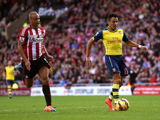 Alexis Sanchez of Arsenal outpaces Wes Brown of Sunderland to score the opening goal during the Barclays Premier League match between Sunderland and Arsenal at the Stadium of Light on October 25, 2014 