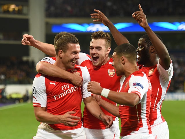 Arsenal's Polish-born German striker Lukas Podolski celebrates with teammates after scoring during a UEFA Champions League group stage football match Anderlecht vs Arsenal at the Constant Vanden Stock stadium in Anderlecht on October 22, 2014