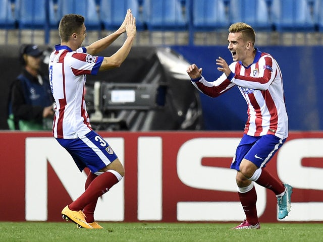 Atletico Madrid's French forward Antoine Griezmann celebrates with Atletico Madrid's Brazilian defender Guilherme Siqueira after scoring the third goal during the UEFA Champions League football match Club Atletico de Madrid vs Malmo FF at the Vicente Cald