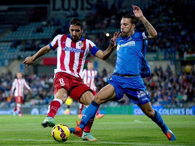Raul Garcia of Atletico Madrid competes for the ball with Alexis Ruano of Getafe CF during the La Liga match between Getafe CF and Club Atletico de Madrid at Coliseum Alfonso Perez on October 26, 2014