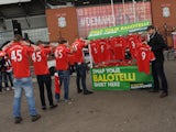 Liverpool fans outside Anfield are offered a replacement shirt for their 'Balotelli 45' replicas by Paddy Power