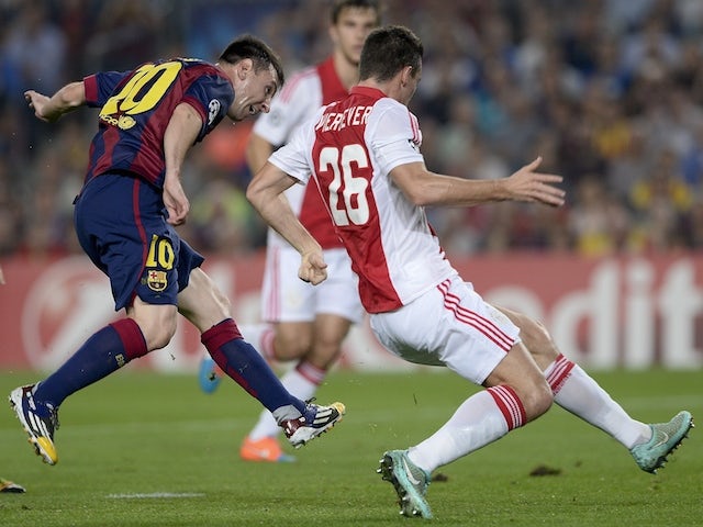 Barcelona's Argentinian forward Lionel Messi (L) scores during the UEFA Champions League football match FC Barcelona vs Ajax Amsterdam at the Camp Nou stadium in Barcelona on October 21, 2014
