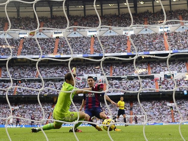 Iker Casillas intercepts as Lionel Messi takes a shot at goal during the El Clasico at the Bernabeu on October 25, 2014