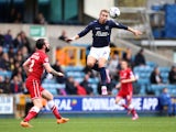 Lee Martin of Millwall jumps to head a ball under pressure from John Brayford of Cardiff during the Sky Bet Championship match between Millwall and Cardiff City at The Den on October 25, 2014