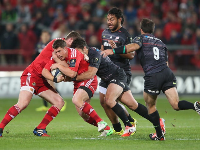 Ian Keatley of Munster is tackled by Brad Barritt during the European Rugby Champions Cup match between Munster and Saracens at Thomond Park on October 24, 2014