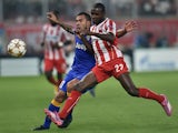 Olympiacos' Eric Abidal fights for the ball with Juventus' Carlos Tevez during the Group A Champions League football match Olympiacos vs Juventus at the Karaiskaki stadium in Athens' Piraeus district on October 22, 2014