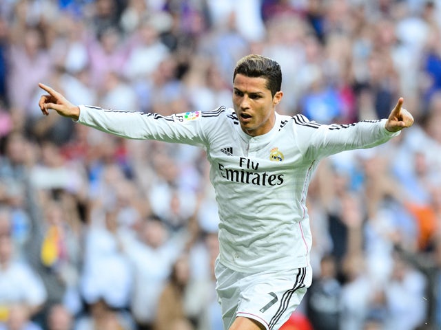 Real Madrid's Portuguese forward Cristiano Ronaldo celebrates after scoring during the Spanish league 'Clasico' football match Real Madrid CF vs FC Barcelona at the Santiago Bernabeu stadium in Madrid on October 25, 2014.