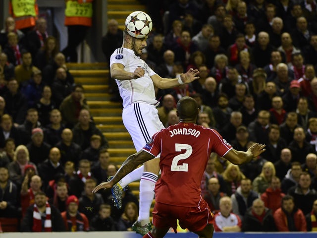 Real Madrid's French forward Karim Benzema rises above Liverpool's English defender Glen Johnson to score Real Madrid's second goal during the UEFA Champions League, group B, football match between Liverpool and Real Madrid at Anfield in Liverpool, northw