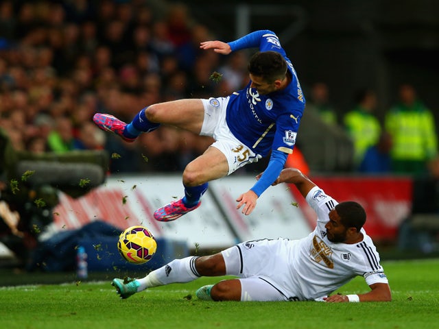 Ashley Williams of Swansea City tackles David Nugent of Leicester City during the Barclays Premier League match between Swansea City and Leicester City at Liberty Stadium on October 25, 2014
