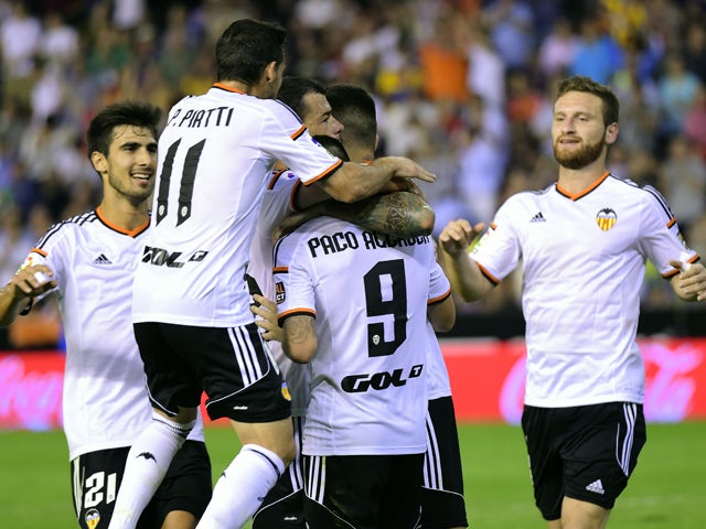 Valencia's players celebrate after scoring their third goal during the Spanish league football match Valencia FC vs Elche CF at the Mestalla stadium in Valencia on October 25, 2014
