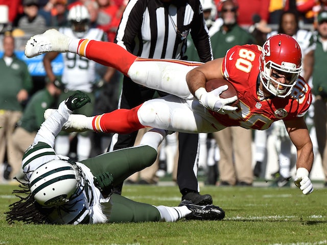 Anthony Fasano #80 of the Kansas City Chiefs dives over Marcus Williams #22 of the New York Jets during the first half at Arrowhead Stadium on November 2, 2014