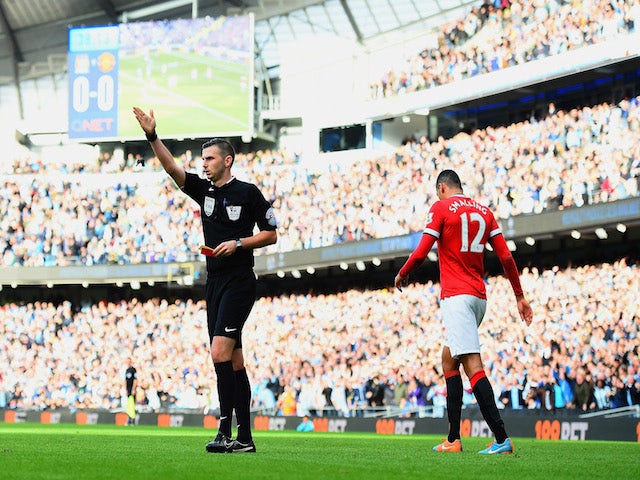 Chris Smalling of Manchester United leaves the field after receiving a red card by Referee Michael Oliver during the Barclays Premier League match against Manchester City on November 2, 2014