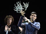 Brazilian football player David Luiz applauds Serbia's Novak Djokovic (R) posing with his trophy after winning the final match against Canada's Milos Raonic at the Paris Masters Final on November 2, 2014