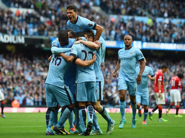 Sergio Aguero of Manchester City is mobbed by team mates after scoring the opening goal during the Barclays Premier League match against Manchester United on November 2, 2014
