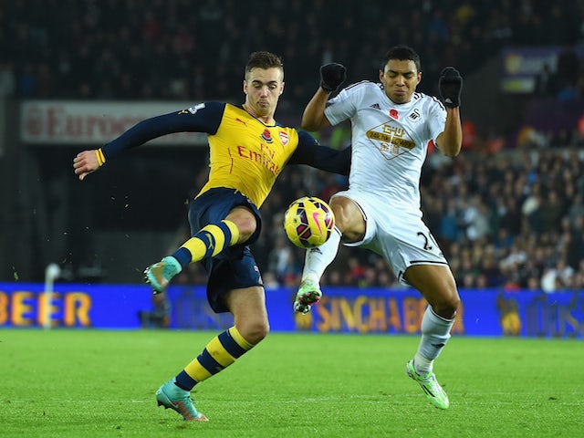 Arsenal player Calum Chambers is challenged by Swansea player Jefferson Montero during the Barclays Premier League match on November 9, 2014