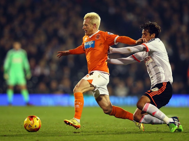 Bryan Ruiz of Fulham tackles David Perkins of Blackpool during the Sky Bet Championship match between Fulham and Blackpool at Craven Cottage on November 5, 2014