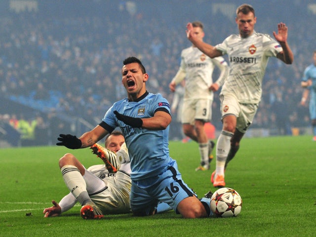 Manchester City's Argentinian striker Sergio Aguero is challenged by CSKA Moscow's defender Sergey Ignashevich before he was shown the yellow card for diving gets a yellow card for diving during the UEFA Champions League Group E football match between Man