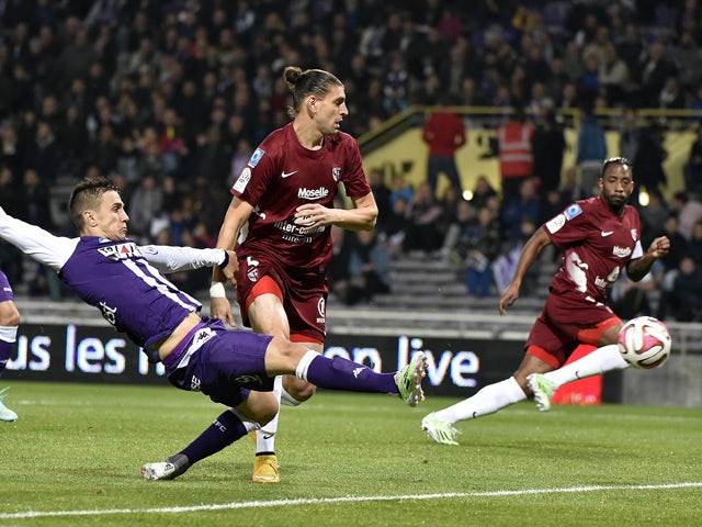 Toulouse's Serbian forward Aleksandar Pesic vies with Metz' Italian-Argentine defender Guido Milan during the French L1 football match between Toulouse FC and FC Metz at the Stadium Municipal in Toulouse, southern France, on November 8, 2014
