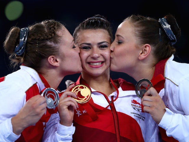 Claudia Fragapane of England is kissed on the podium by Ruby Harrold and Hannah Whelan after winning the Women's All-Around Final at the SECC Precinct during day seven of the Glasgow Commonwealth Games on July 30, 2014